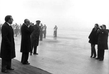 El vicepresidente primero del Gobierno, Manuel Gútierrez Mellado, fotografía a la reportera gráfica Queca Campillo, tras despedir al canciller alemán Helmut Schmidt en Barajas en 1980.