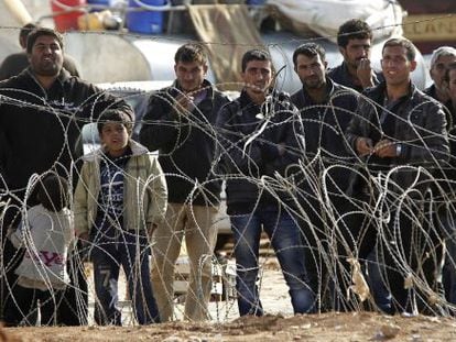 Refugiados sirios esperan para cruzar la frontera y pasar a Turqu&iacute;a.