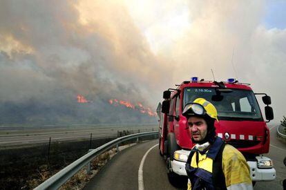 Un efectivo del cuerpo de bomberos observa en la AP-7 las llamas del incendio forestal declarado hacia las 13 horas en La Jonquera (Girona).