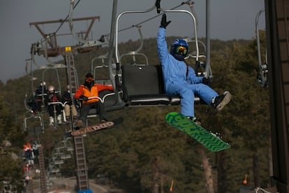 Una niña con su tabla de snow, en el telesilla de la pista del Escaparate.