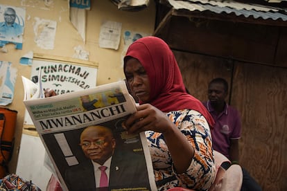 Una mujer lee un periódico en cuya portada se informa de la muerte del presidente del Gobierno tanzano, John Magufuli, en Dar es Salam, Tanzania, este jueves.