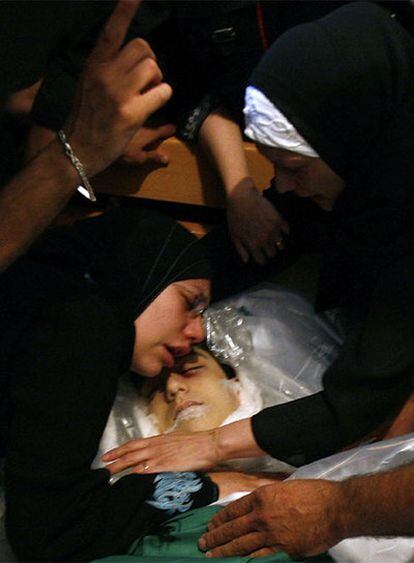 Familiares de un joven de 16 años muerto en los enfrentamientos en Beirut velan su cadáver.