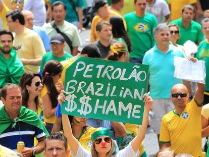Una dona sosté un cartell que diu 'Petroli brasiler, vergonya'.