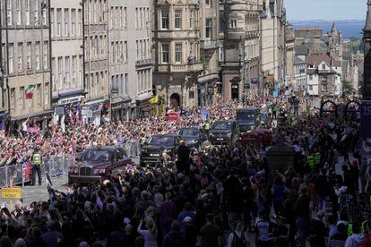 Centenares de personas se han congregado en la Royal Mile, en el centro de Edimburgo, en la que ha tenido lugar la llamada 'Royal Procession'. En la imagen, el paso de los coches que llevaba a los reyes y los príncipes de Gales a la catedral de St Giles.