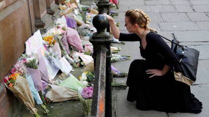 Una mujer deja flores por las víctimas del atentado en el Manchester Arena en mayo.