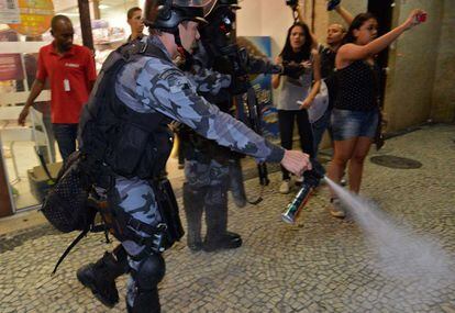 Un agente de policía rocía con un spray a los participantes en las protestas contra la llegada del Papa a Río de Janeiro (Brasil), 22 de julio de 2013.