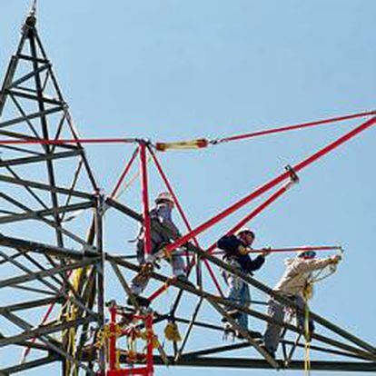 Operarios de Red Eléctrica en una torre de alta tensión.