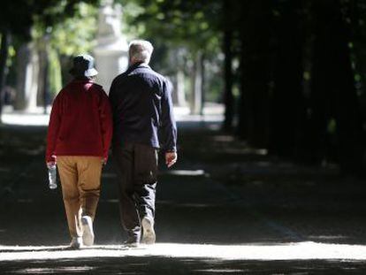 Una pareja mayor camina en el madrileño parque de El Retiro.