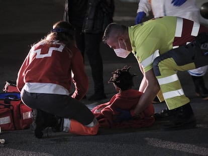 Uno de los niños atendidos por los servicios de emergencia en la noche del martes, sobre el asfalto del muelle de Arguineguín.