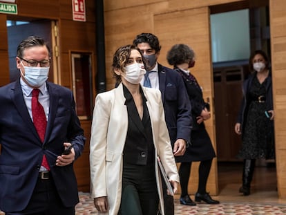 La presidenta de la Comunidad de Madrid, Isabel Díaz Ayuso (En primer término), llega al hemiciclo acompañada de Alfonso Serrano, portavoz parlamentario del PP, y, detrás, de David Pérez, consejero de Vivienda.