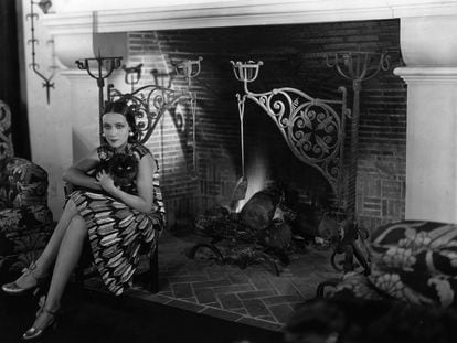 Dolores Del Rio, sentada ante la chimenea de su casa con su gata 'Joan'. "Es la más grande que jamás haya visto”, escribió sobre la chimenea Grace Kingsley, la primera crítica de cine de 'Los Angeles Times'.
