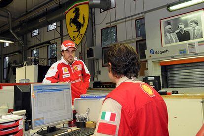 Fernando Alonso conversa con un técnico de Ferrari en la fábrica de Maranello.