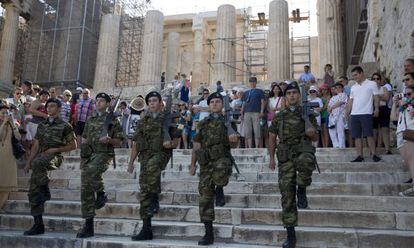 Un grupo de soldados abandona la Acrópolis, en Atenas, este martes tras el izado de la bandera.