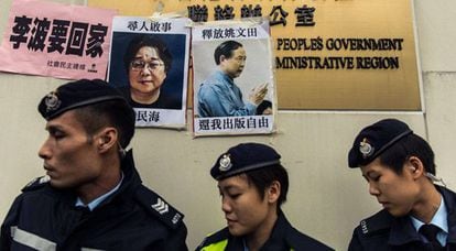 Policías junto a carteles de dos desaparecidos, el domingo en Hong Kong.