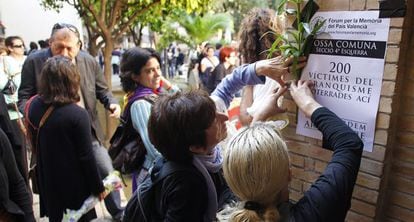 Miembros del Fòrum de la Memòria colocan carteles en el Cementerio General de Valencia.