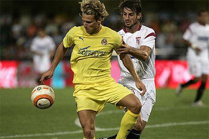 Diego Forlán, delantero uruguayo del Villarreal, lucha por el balón con Héctor Ocio, del Sevilla.