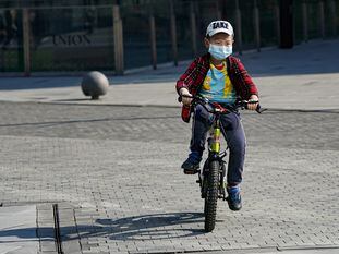 Un niño monta en bicicleta en Pekín. (Fred Lee/Getty Images) | En vídeo, un médico alerta del peligro del coronavirus también para los jóvenes.