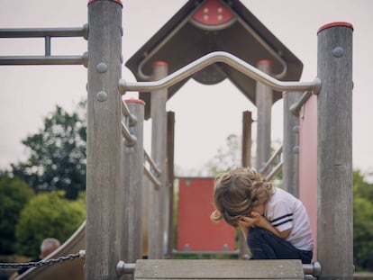 Un niño llora en un columpio.