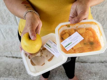 Josefa Labrada posa con el menú repartido por la Comunidad de Madrid en una escuela primaria en el barrio de La Peseta en Madrid.