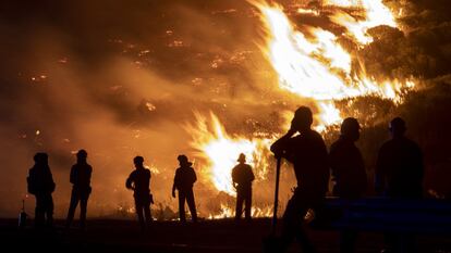 Bomberos forestales y vecinos de la zona observan las llamas en el incendio forestal del pasado agosto en Navalacruz, en Ávila.