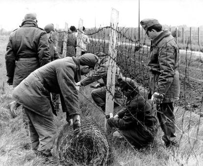 Guardias h&uacute;ngaros retiran la alambrada de la frontera con Austria en 1989.