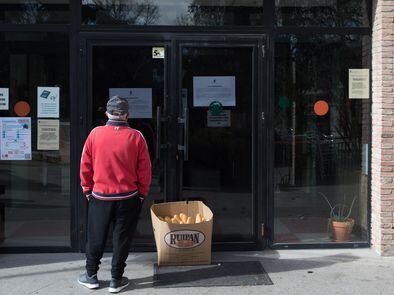 Un jubilado lee la nota informativa que explica el cierre del Centro Municipal de Mayores de Valdemoro (Madrid).