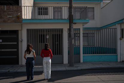 Dos jóvenes activistas frente a la casa donde operaban falsas organizaciones feministas, en Orizaba, en diciembre de 2023.