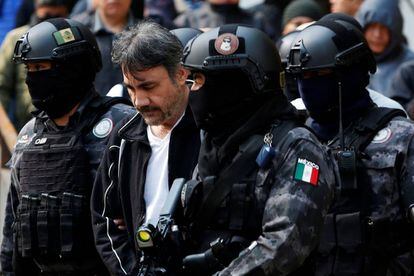 Damaso López escoltado en Ciudad de México por policías después de ser detenido.