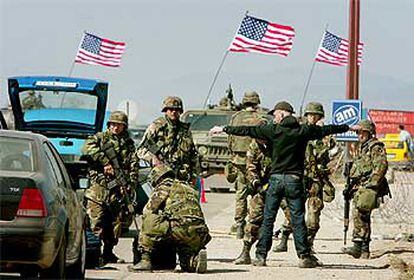 Soldados estadounidenses registran a los automovilistas en la carretera que une las ciudades kosovares de Pristina y Mitrovica.