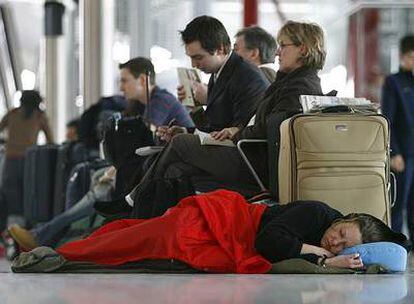 Una mujer duerme en el suelo en la T-5 de Londres-Heathrow durante la caótica apertura de la nueva terminal.