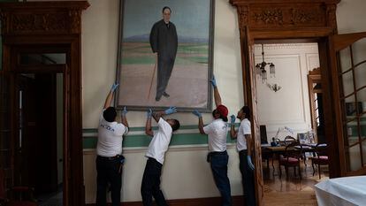 Unos operarios descuelgan en el Ateneo el retrato de Antonio Machado, pintado por Cristóbal Ruiz en 1926, para su traslado temporal a España.
