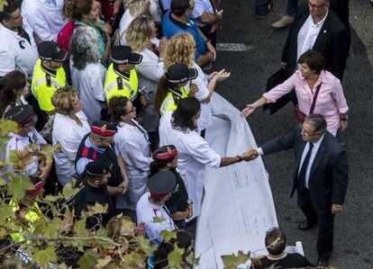 El ministre de l'Interior, Juan Ignacio Zoido, amb la vicepresidenta del Govern, Soraya Sáenz de Santamaría, saluden els representants dels cossos de seguretat, emergències i d'entitats veïnals i ciutadanes que encapçalaran la manifestació.