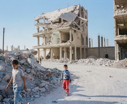Dos niños caminan por el centro de la ciudad kurda de Kobane, en la frontera sirio-turca.