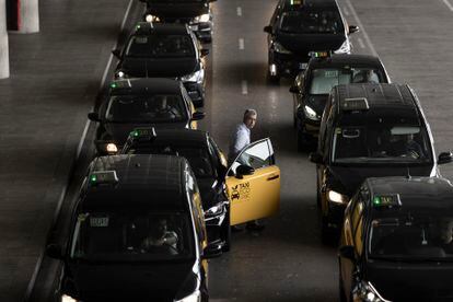 Taxistas hacen cola para la recogida de clientes en el aeropuerto de El Prat de Barcelona, este jueves.