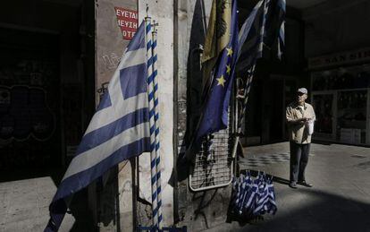 Un anciano ante una tienda que vende banderas griegas y de la UE en el centro de Atenas.