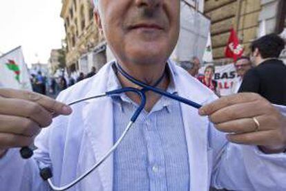 Un trabajador de Sanidad simula ahorcarse con un estetoscopio durante una manifestación a las puertas del Ministerio de Economía en Roma (Italia). EFE/Archivo