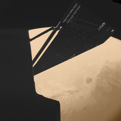 Uno de los paneles solares de la <i>Rosetta</i> y la superficie de Marte al fondo se aprecian esta fotografía tomada por la cámara de la nave cuatro minutos antes de su máximo acercamiento al planeta rojo (mil kilómetros), durante uno de los sobrevuelos.