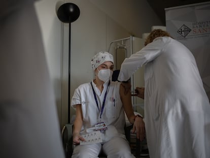 Una enfermera vacuna a un profesional sanitario con la vacuna de Pfizer-BioNtech contra la covid-19 en el hospital de la Santa Creu i Sant Pau de Barcelona.