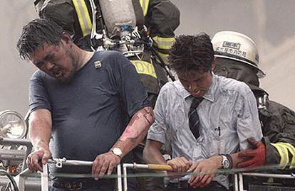 Los bomberos rescatan a dos hombres después de la explosión de un edificio de oficinas, ayer, en Nagoya (Japón).
