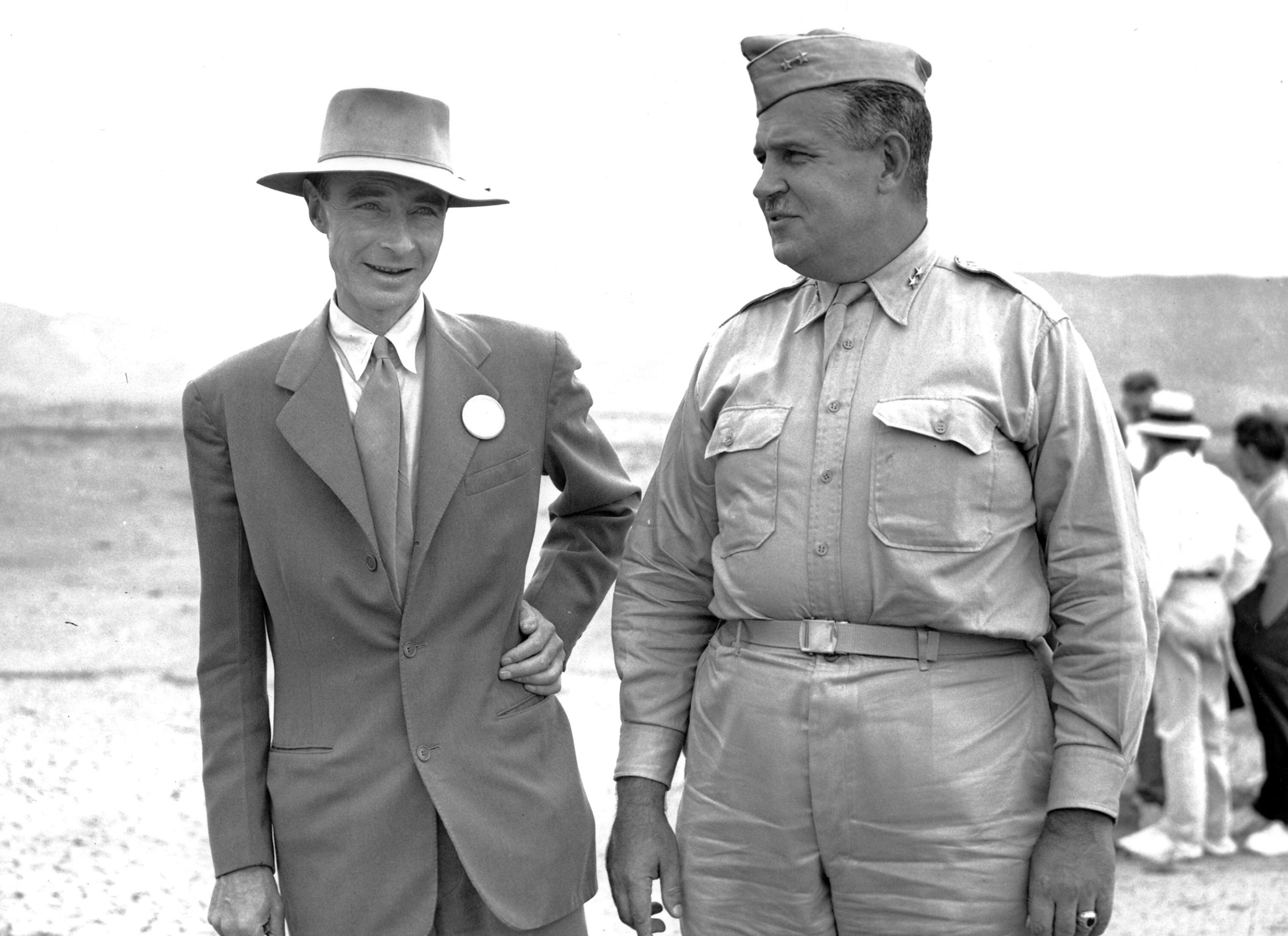 El general John Leslie R. Groves y Robert Oppenheimer inspeccionan el sitio del primer test de la bomba atómica en 1945. 