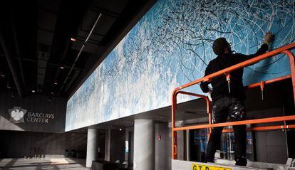 José Parlá, encaramado al andamio sobre el que pintó el mural del Barclays Center.