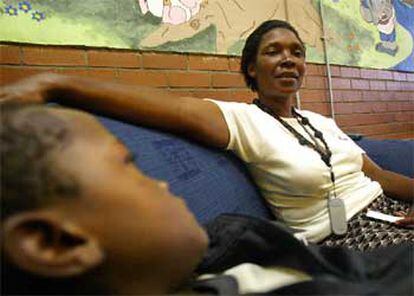 La surafricana Princess Mbatha y su hijo Johannes, ambos seropositivos, esperan antivirales en Soweto.