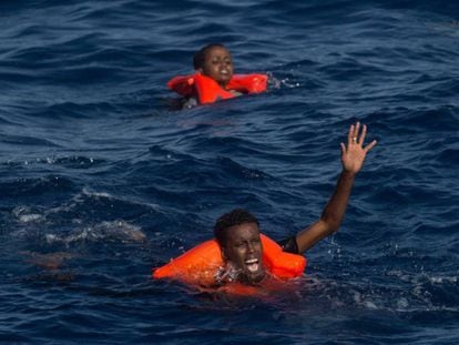 Dos náufragos subsaharianos piden auxilio tras zozobrar su embarcación cerca de la costa de Libia. / C. MCGRATH (GETTY IMAGES)