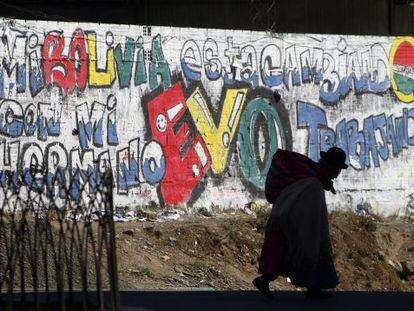 Una boliviana pasea frente a una pintada en apoyo a Morales.