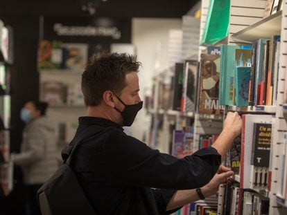 Un hombre busca en una estantería de una librería de Madrid.