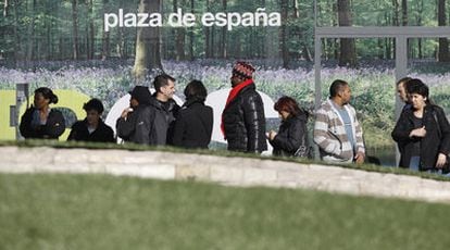 Arriba, vecinos de Torrejón hacen cola en la estación de autobuses de la localidad. Abajo, una réplica de la Puerta de Brandeburgo en Parque Europa.