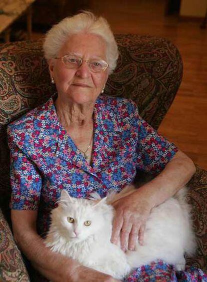 María Catalina, en su casa de Madrid, acaricia a su gato.