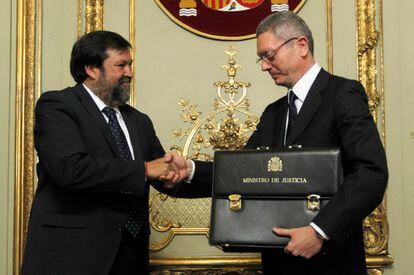 El nuevo ministro de Justicia, Alberto Ruiz-Gallardón (d), recibe la cartera de titular del departamento de manos de su antecesor, Francisco Caamaño, con quien formaliza el traspaso de poderes, el 22 de diciembre de 2011.