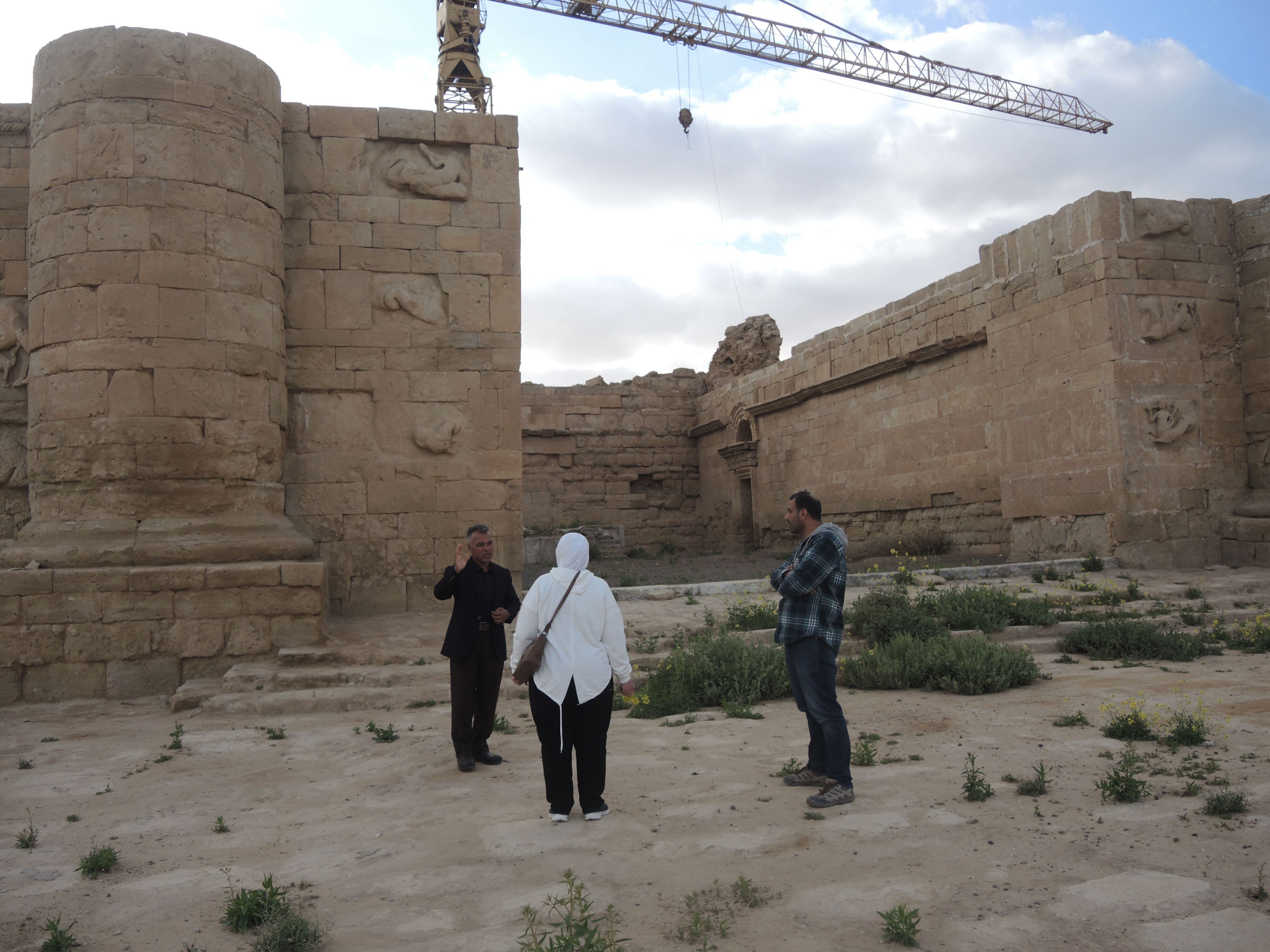 Ali Almakhzomy, agente de viajes, escucha al guía local Mahmoud Abo Saif junto a otra turista iraquí en las ruinas de la ciudad de Hatra, este 2 de abril.