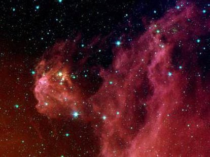 Estrellas nacientes, en el interior de nubes rojizas, en Orión, a 1.300 años luz de la Tierra.